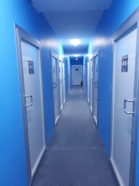 Aras tesisinde kilitli oda kapılarının sıralandığı koridor